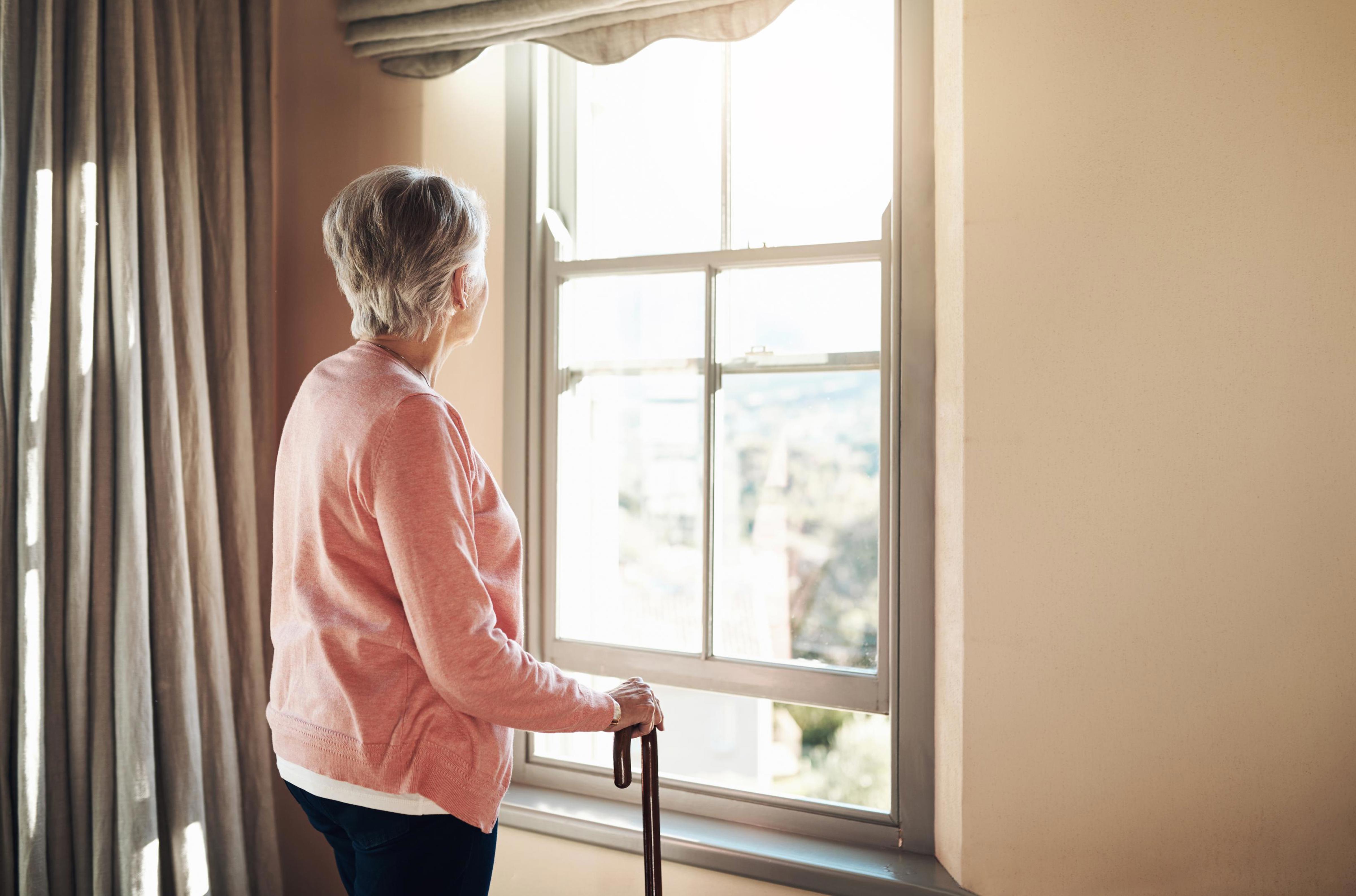 senior woman looking out window_Drees